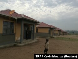 A boy walks past a row of houses in Kyakaboga resettlement village in Hoima District, Uganda, July 14, 2018.