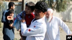 Men carry children away from an explosion site in Lashkar Gah, capital of southern Helmand province, Afghanistan, Feb. 24, 2018.