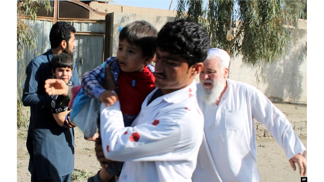 Ljudi odnose decu podalje od mesta eksplozije u Laškar Gahu, glavnom gradu južne avganistanske provincije Helmand, Avganistan, 24. februara 2018.