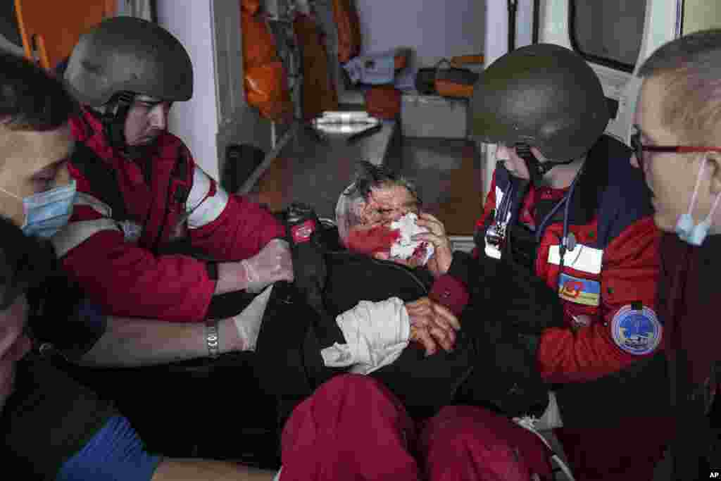 Paramedics move a wounded civilian onto a stretcher to a maternity hospital converted into a medical ward in Mariupol, March 2, 2022.