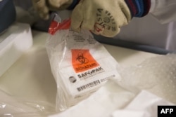 FILE - A photo released by the World Health Organization Oct. 22, 2014, shows the receipt by Geneva University Hospital (HUG) of a batch of the experimental rVSV Ebola vaccine developed at the National Microbiology Laboratory in Winnipeg, Canada.