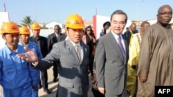 中国外交部长王毅（右二）在塞内加尔文化部长阿卜杜•阿西塞•姆巴耶（右一）的陪同下，参观中国投资的塞内加尔“黑人文明”博物馆的建筑工地。