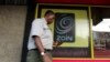 FILE - A man uses his mobile phone as he walks past a Zain customer care shop in Nairobi, Kenya, Feb. 15, 2010. Political activists in South Sudan have accused Zain South Sudan of disrupting their phone service ahead of a planned protest.