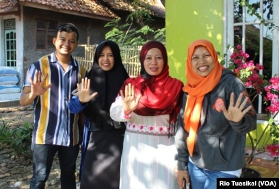 Warga Indramayu, Jawa Barat, menunjukkan gestur "stop kawin anak" saat ditemui VOA, awal September. (VOA/Rio Tuasikal)