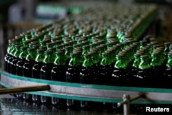 FILE - Bottles of beer move along a production line at a factory of Saigon Beer Corporation (Sabeco) in Hanoi, Vietnam, June 23, 2017.
