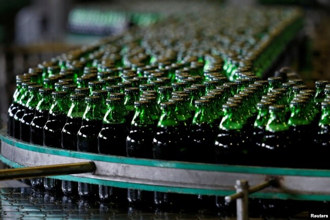 FILE - Bottles of beer move along a production line at a factory of Saigon Beer Corporation (Sabeco) in Hanoi, Vietnam, June 23, 2017.
