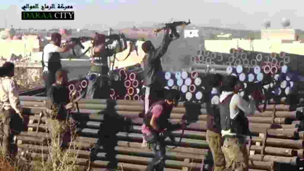 This image taken from video from the Sham News Network shows Syrian opposition fighters firing at government forces near Daraa, Sept. 25, 2013.