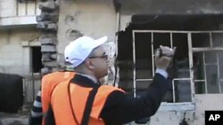In this image made from amateur video released by Shaam News Network purports to show Arab League monitors visiting the Baba Amr area of Homs in Syria, December 28, 2011. (AP cannot independently verify the content, date, location or authenticity of this 