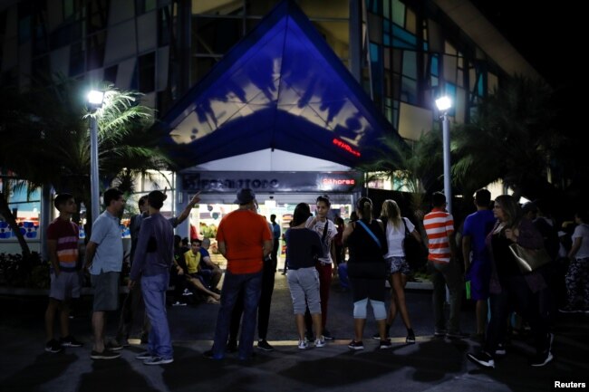People line up outside a pharmacy to try to buy goods during a blackout in Caracas, Venezuela, March 8, 2019.