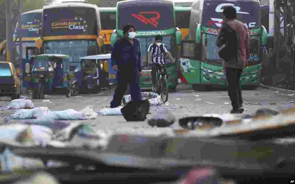 People walk along the Central Highway while it is blocked as part of a transportation strike in Chaclacayo, in Lima, Peru.