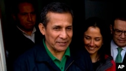 FILE- Peru's former President Ollanta Humala and his wife, Nadine Heredia, talk with journalists as they leave the headquarters of Peru's National Party in Lima, Peru, July 13, 2017.