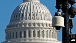 FILE - Surveillance cameras are visible near the U.S. Capitol in Washington.