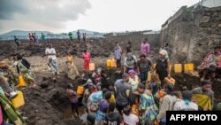 Wakazi wa Goma wakusanyika kwenye kituo cha maji wakati ikiwepo hofu ya mlipuko mpya wa volcano karibu na kulikotokea mlipuko mwengine wiki moja iliyopita kwenye mlima Nyiragongo, Ijumaa, Mei 25, 2021.(Photo by Moses Sawasawa / AFP).