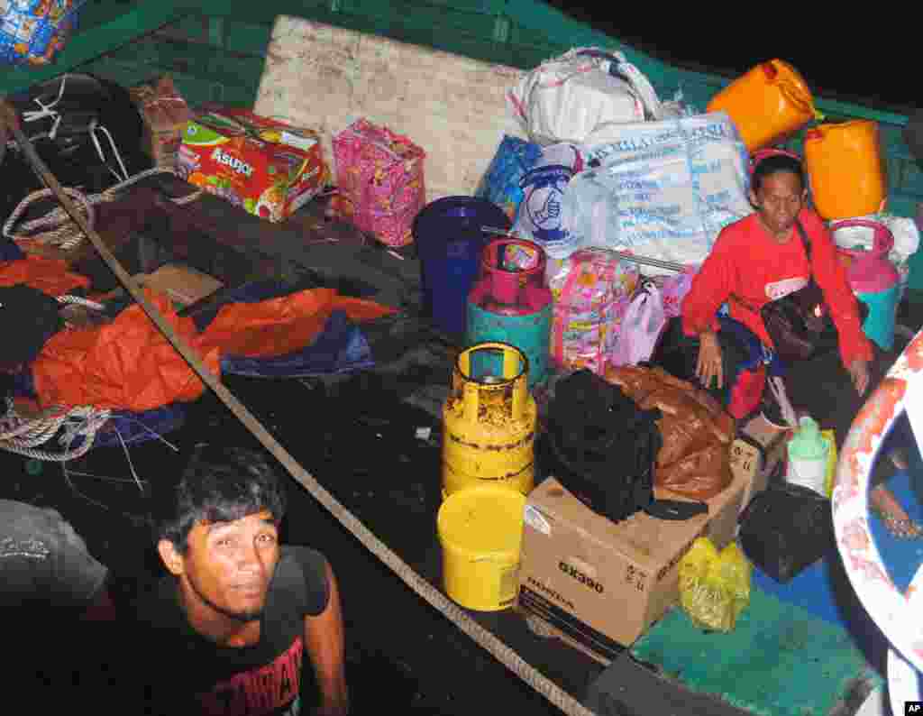Philippine residents who fled Malaysia's Sabah state arrive with their belongings in the southern Philippines, March 4, 2013.