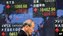 Papan saham elektronik dari perusahaan sekuritas di Tokyo (31/10). (AP/Eugene Hoshiko)