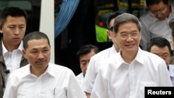 Zhang Zhijun (R), director of China's Taiwan Affairs Office, arrives with New Taipei City Deputy Mayor Hou You-yi, at the labor activity center in New Taipei City, June 26, 2014. 