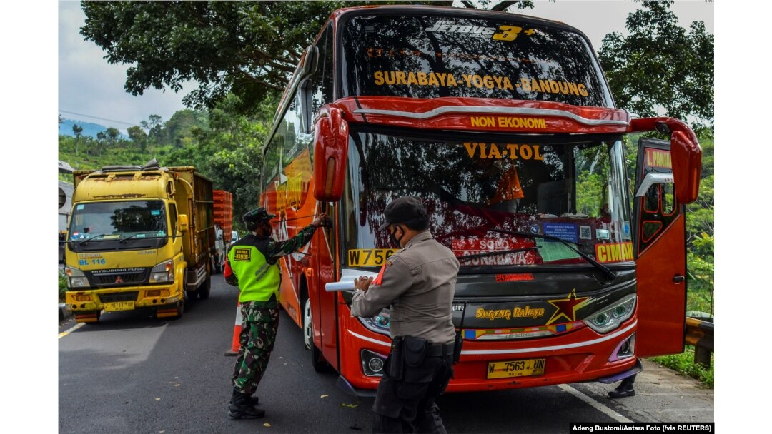 Para petugas memeriksa sebuah bus penumpang pada hari pertama penerapan larangan mudik nasional untuk mencegah penyebaran pandemi COVID-19, di Tasikmalaya, Jawa Barat, 6 Mei 2021. (Adeng Bustomi/ Antara Foto via Reuters)