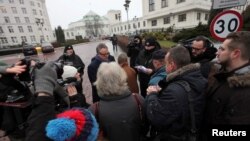 Media representatives wait to enter for a meeting with the Speaker of Senate during the fourth day of a protest in front of the Parliament building in Warsaw, Poland, Dec. 19, 2016. 