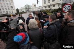 Media representatives wait to enter for a meeting with the Speaker of Senate during the fourth day of a protest in front of the Parliament building in Warsaw, Poland, Dec. 19, 2016.