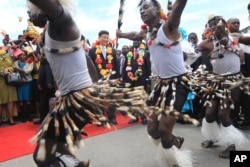 Chinese President Xi Jinping, centre, and Zimbabwean President Robert Mugabe, centre right, watch a performance by Zimbabwean traditional dancers upon his arrival in Harare, Zimbabwe.