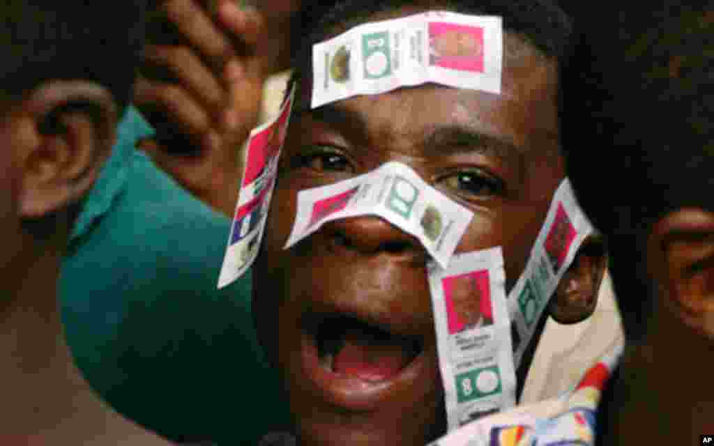 A supporter of Haiti's presidential candidate Michel Martelly, with Martelly's electoral stickers on his face, waits to meet the candidate outside his home in Peguy Ville December 9, 2010. Haiti's electoral authorities said on Thursday they would urgently
