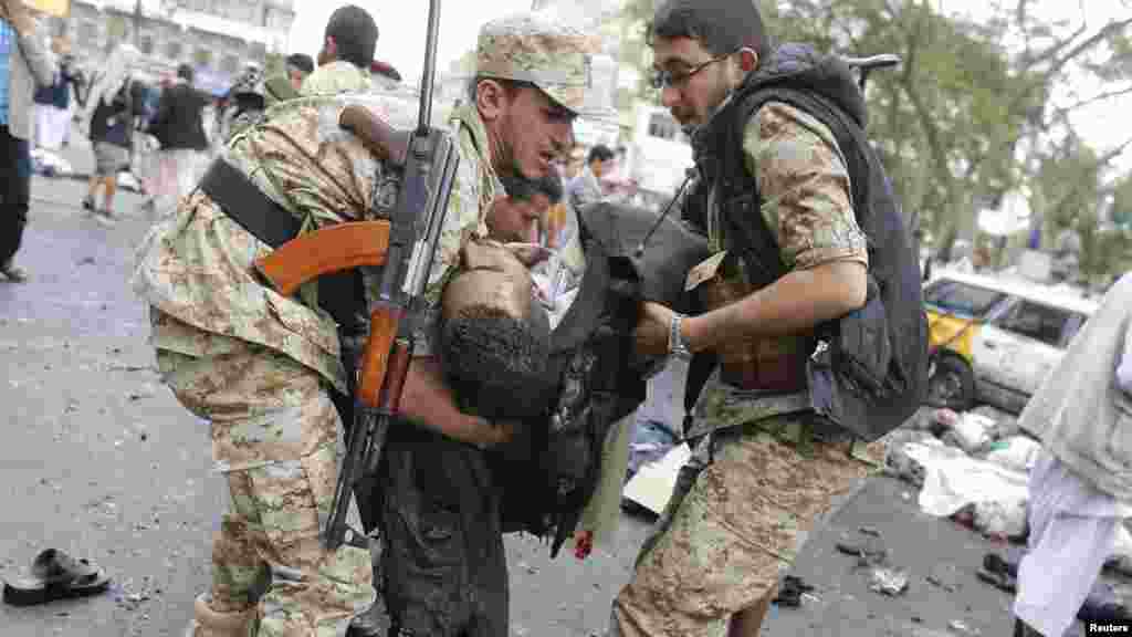 Une victime de l&rsquo;attentat suicide portée par les agents de la sécurité après l&rsquo;explosion d&rsquo;une bombe à Sanaa, Yémen, jeudi le 9 octobre 2014. REUTERS 