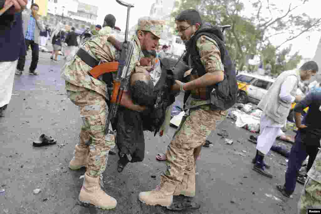 Shi&#39;ite Houthi rebels carry a dead man at the scene of a suicide attack in Sana&#39;a, Oct. 9, 2014. 