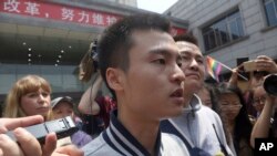 Sun Wenlin, center left, and his partner Hu Mingliang, center right, speak to journalists after a judge ruled against them in China's first gay marriage case in Changsha in central China's Hunan province. (AP Photo/Gerry Shih)