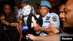 Convicted Australian drug trafficker Schapelle Corby is escorted by police from the prosecutor's office in Denpasar, on the resort island of Bali, Feb. 10, 2014.