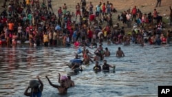 Des migrants, dont beaucoup d'Haïti, traversent le Rio Grande à pied depuis Del Rio, au Texas, pour retourner à Ciudad Acuña, au Mexique, le dimanche 19 septembre 2021, afin d'éviter l'expulsion des États-Unis vers Haïti. (Photo AP/Félix Marquez)