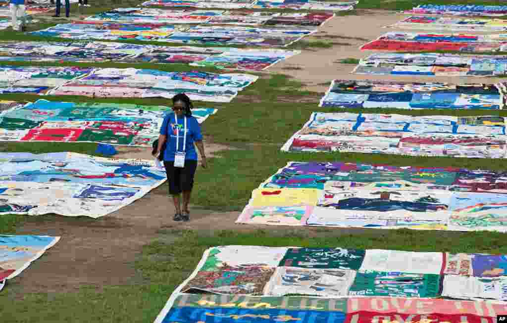 Phangisile Mtshali walks among the panels of the AIDS Memorial Quilt on display at The National Mall in Washington, July 23, 2012. The quilt is being displayed in its entirety for the first time since 1996.