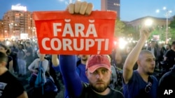 A man holds a poster that reads "Without Corruption" during a protest in Bucharest, Romania, May 3, 2017. 