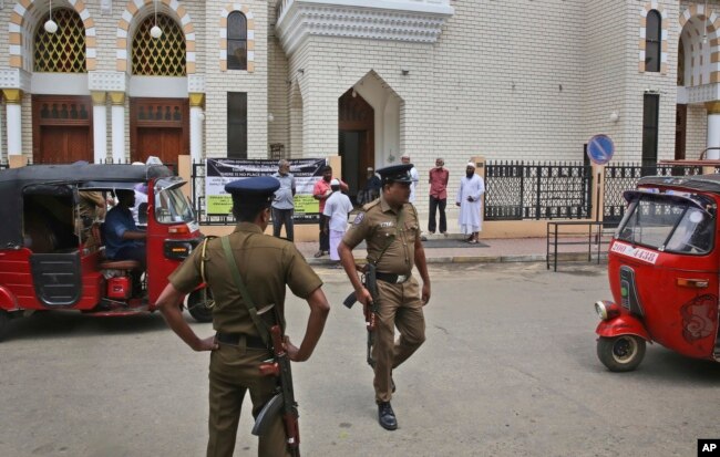 Sri Lankan policemen stand guard outside a mosque before the Friday prayers, in Colombo, Sri Lanka, April 26, 2019.