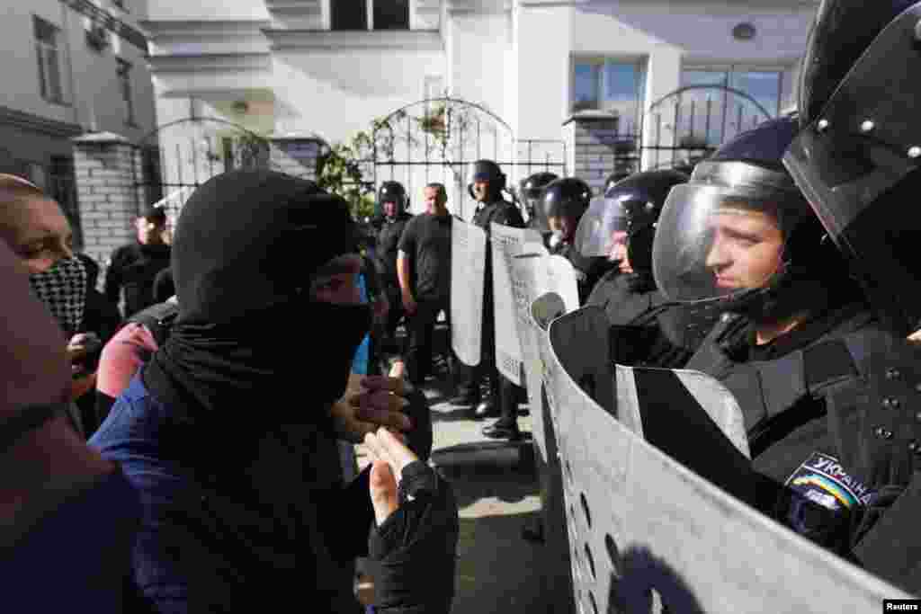 Activists of a pro-Ukrainian radical group talk to riot police officers during a rally outside the Russian embassy in Kyiv, June 22, 2014.