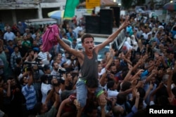 Palestinians celebrate following announcement of a cease-fire in Gaza City Aug. 26, 2014.