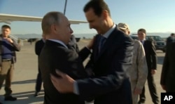 FILE - In this Dec. 11, 2017, frame grab made available by Russian Presidential TV Syrian President Bashar al-Assad, right, greets Russian President Vladimir Putin upon his arrival to the Hemeimeem air base in Syria.