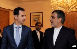 Syrian President Bashar al-Assad, left, meets with Iranian Deputy Foreign Minister for Arab-African Affairs Hossein Jaberi Ansari in Damascus, Syria, Thursday, Dec. 22, 2016.