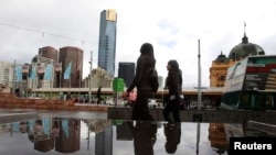 FILE - Office workers walk through Federation Square in Melbourne, Australia, May 11, 2011. Police say suspected terrorists now under arrest had planned to attack the square and other targets.