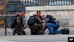 Des policiers fouillent un colis suspect près du tribunal de Paris, en France, 16 novembre 2015.