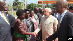 Indian Prime Minister Narendra Modi, centre, is received by Ugandan ministers and dignitaries at State House in Entebbe, about 42 Km from the capital Kampala, July 24, 2018. 