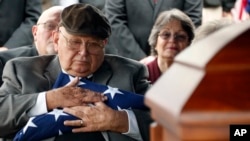 Frank Springs, of Lucedale, hugs the American flag that draped the casket of his uncle, Navy Fireman 1st Class Jim H. Johnston, who was buried, Dec. 7, 2016, with full military honors in Wesson, Miss., his hometown. 