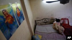 A Pakistani asylum seeker, photographed in January, hides in a small apartment on Bangkok’s edge. Lacking legal status, refugees scrape by while awaiting resettlement. Some have been caught up in Thailand's efforts to curb human trafficking.