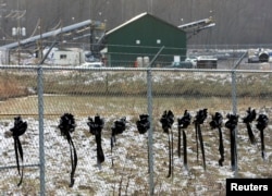 FILE - Twelve ribbons line a fence in front of the Sago Mine in Sago, West Virginia, Jan. 8, 2006. The ribbons honor the 12 miners who died in the Sago Mine after an explosion on January 2.