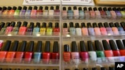 FILE - A wall rack is filled with nail polishes, Nov. 30, 2016, at a salon in Alameda, Calif. A group of Vietnamese-American salon owners in Louisiana accused the state of racial bias and received a $100,000 settlement.