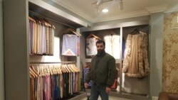 Junaid Shahdhar, executive managing director at the Pashmina manufacturing and marketing company Phamb Fashions Pvt Ltd., showcases Pashmina shawls in Srinagar. (Bilal Hussain/VOA)
