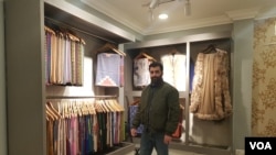 Junaid Shahdhar, executive managing director at the Pashmina manufacturing and marketing company Phamb Fashions Pvt Ltd., showcases Pashmina shawls in Srinagar. (Bilal Hussain/VOA)