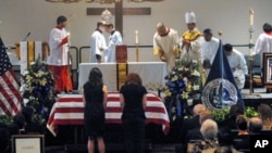 Women bow before the casket of slain U.S. Immigration and Customs Enforcement (ICE) Special Agent Jaime Jorge Zapata during a funeral mass at the Brownsville Events Center in Brownsville, Texas, February 22, 2011