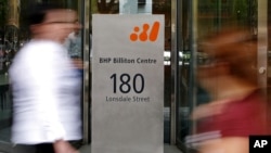 Pedestrians pass the head offices of mining giant BHP Billiton in Melbourne, Australia November 27, 2008 (file photo).