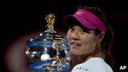 Li Na of China holds the championship trophy at the Australian Open tennis championship.(AP Photo/Andrew Brownbill)