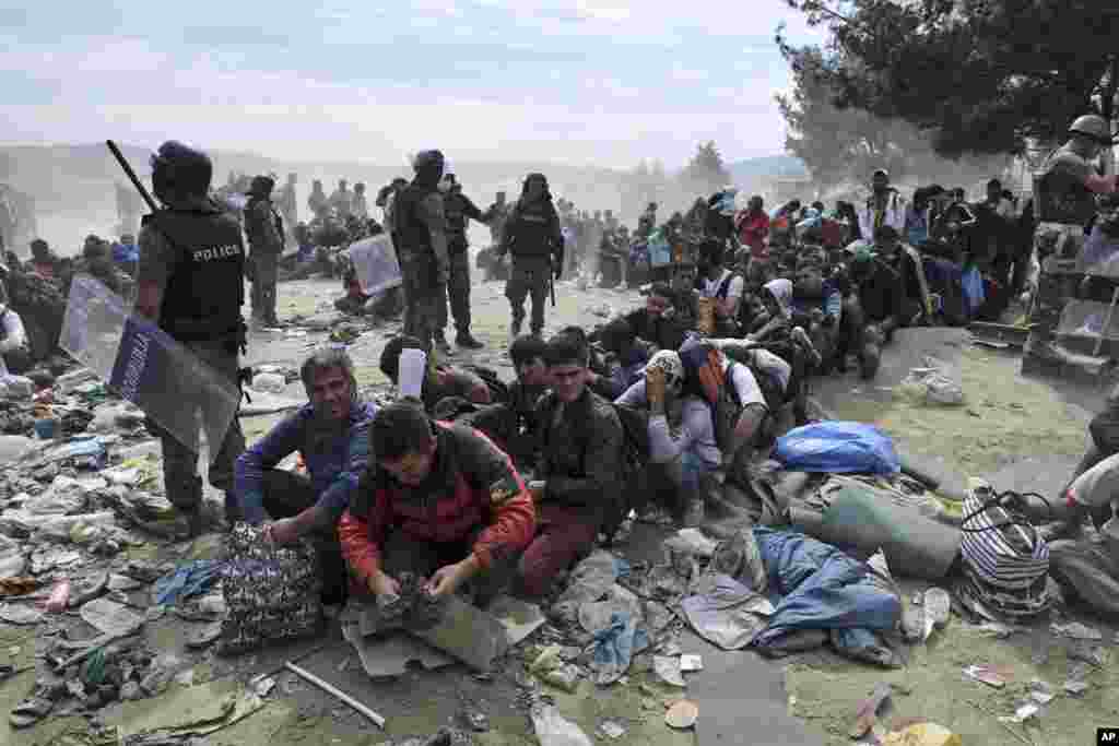 Refugees and migrants wait to cross the border from the northern Greek village of Idomeni to southern Macedonia, Sept. 7, 2015. Greece has borne the brunt of a massive refugee and migration flow of people heading into the European Union.